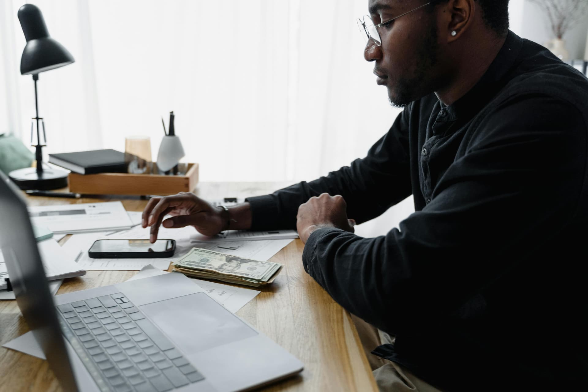 Professional using calculator with financial documents and charts
